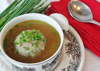 Herb dumpling soup with chives and red napkin.
