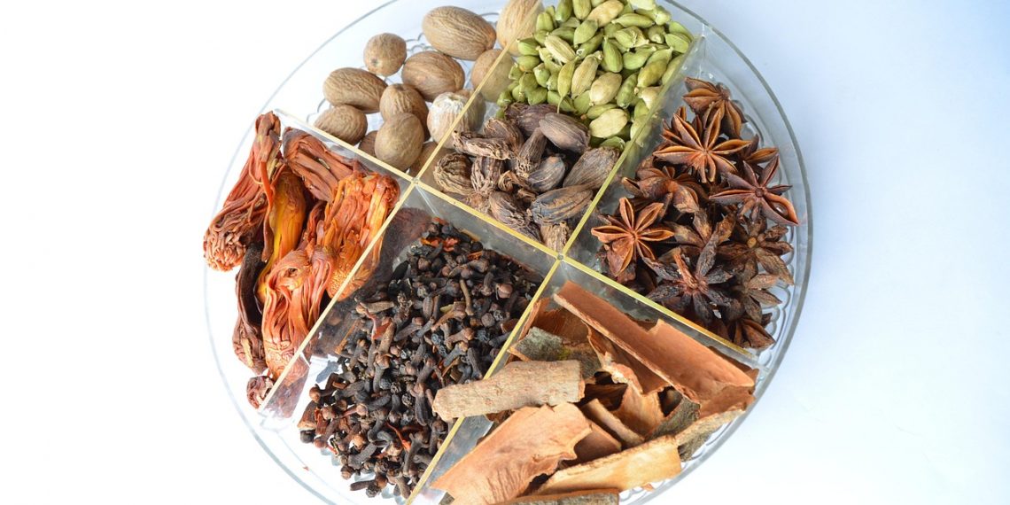 Assorted spices neatly arranged in a round tray.