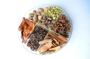 Assorted spices neatly arranged in a round tray.