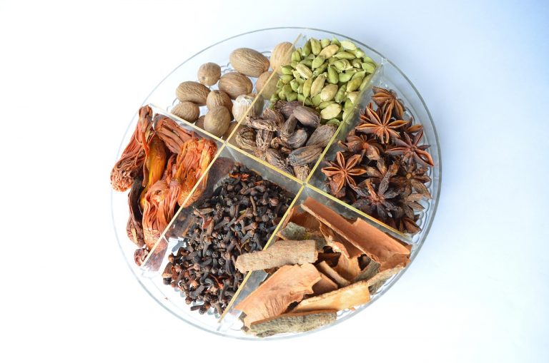Assorted spices neatly arranged in a round tray.
