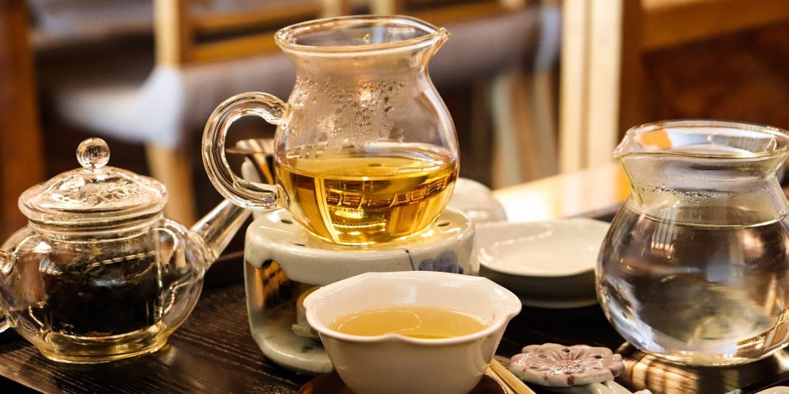 Brewing herbal tea in a glass teapot set for relaxing teatime.