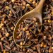 Dry cloves on a wooden spoon, ideal for cooking spices.