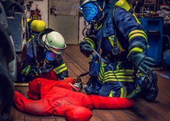 Firefighters performing a rescue drill with a dummy.