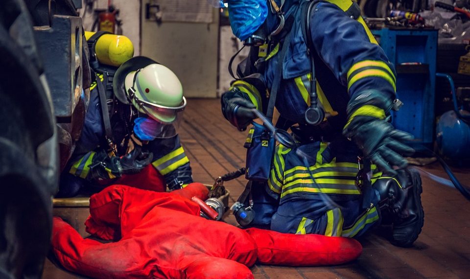 Firefighters performing a rescue drill with a dummy.