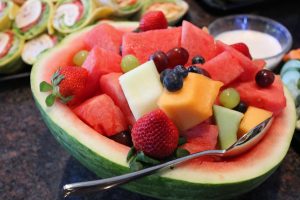 Fruit salad in watermelon bowl with diverse fresh fruits.