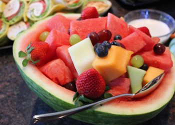 Fruit salad in watermelon bowl with diverse fresh fruits.