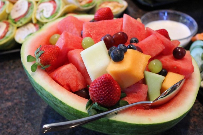Fruit salad in watermelon bowl with diverse fresh fruits.