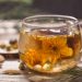 Herbal tea with a blooming flower in a glass cup.