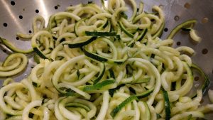 Zucchini noodles in a colander, perfect for a healthy low-carb meal.