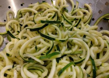 Zucchini noodles in a colander, perfect for a healthy low-carb meal.