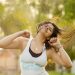 Woman joyfully dancing outdoors in a Zumba class.