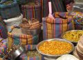 Bags and bowls of colorful spices at a market stall.