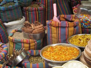 Bags and bowls of colorful spices at a market stall.