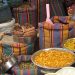 Bags and bowls of colorful spices at a market stall.