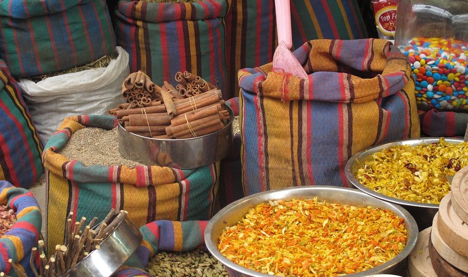 Bags and bowls of colorful spices at a market stall.