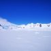 Snowy mountain range under a clear blue sky in Antarctica.