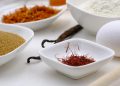 Saffron, sugar, flour, and egg arranged in white bowls for baking.