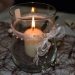 Elegant candle with ribbon decoration in glass holder.