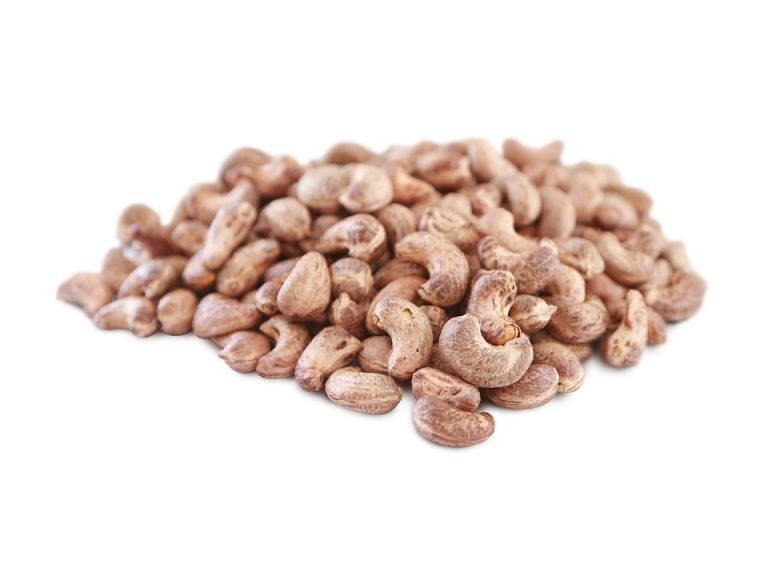 Raw cashew nuts piled on white background.
