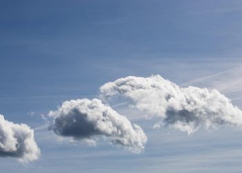 Fluffy clouds in a clear blue sky.