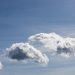 Fluffy clouds in a clear blue sky.