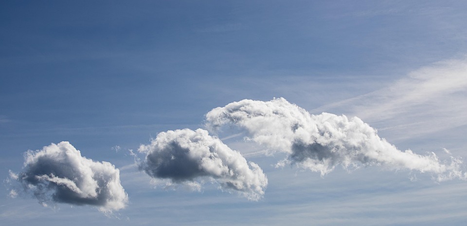 Fluffy clouds in a clear blue sky.