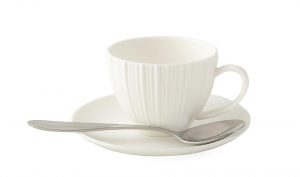 White ceramic teacup with spoon on matching saucer.