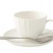 White ceramic teacup with spoon on matching saucer.