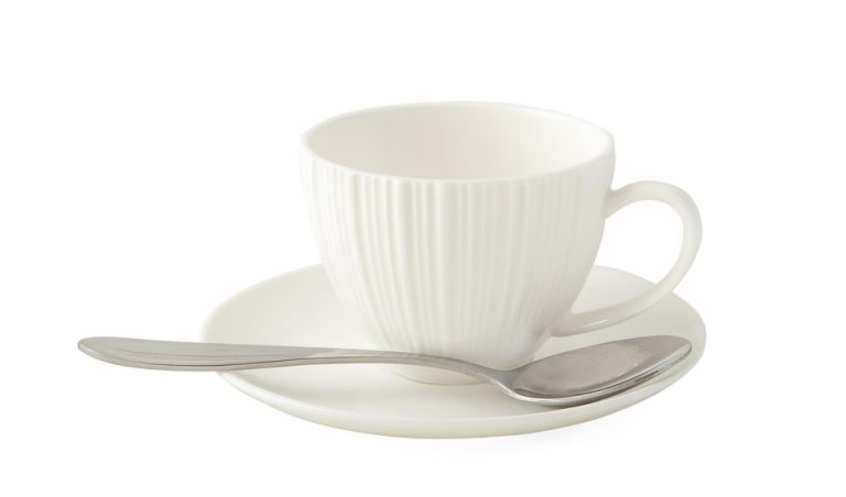 White ceramic teacup with spoon on matching saucer.
