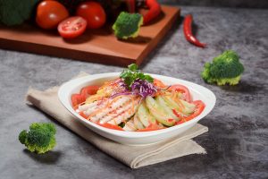 Fresh vegetable salad with tomatoes, cucumbers, and herbs, garnished with cilantro.
