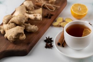 Ginger tea with lemon and cinnamon sticks on a table.