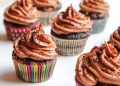 Chocolate cupcakes topped with rich frosting in colorful wrappers.