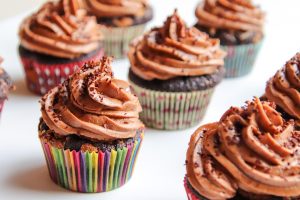 Chocolate cupcakes topped with rich frosting in colorful wrappers.