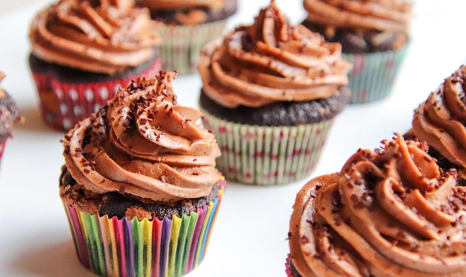 Chocolate cupcakes topped with rich frosting in colorful wrappers.