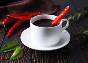 Spicy hot chocolate with a red chili garnish.