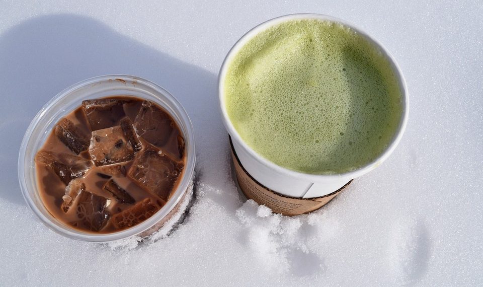 Chilled iced chocolate and hot matcha latte on snow.