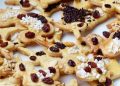 Cookies topped with raisins and chocolate sprinkles.