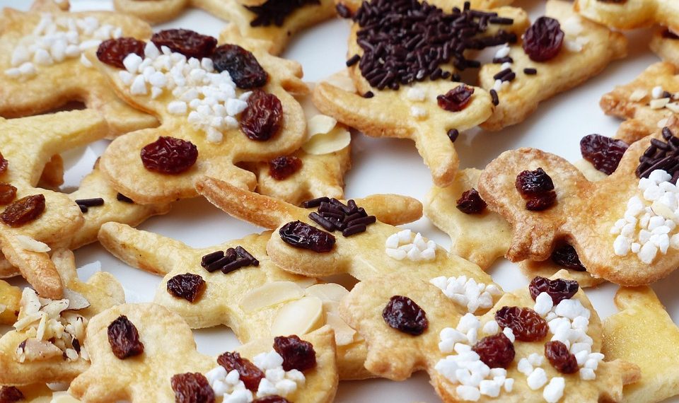Cookies topped with raisins and chocolate sprinkles.