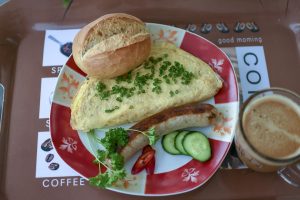 Omelette with sausage, bread, and coffee breakfast.