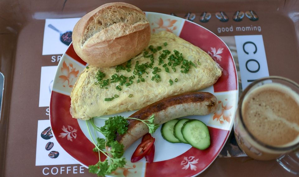 Omelette with sausage, bread, and coffee breakfast.