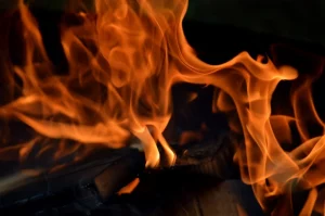Fiery orange flames flicker intensely over burning wood.