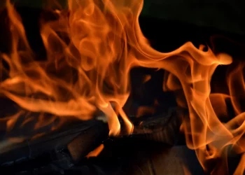 Fiery orange flames flicker intensely over burning wood.