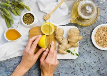 Slicing fresh lemon and ginger for herbal tea preparation.