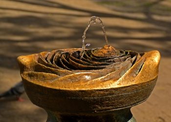 Decorative stone garden fountain with flowing water.