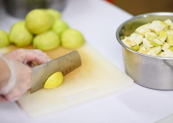 Chopping fresh guavas on a cutting board for a fruit salad.
