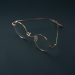 Round rose gold eyeglasses on a dark background.