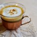 Creamy cappuccino in a glass cup on a lace doily.