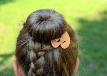 Braided hairstyle with decorative orange clip.