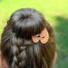 Braided hairstyle with decorative orange clip.
