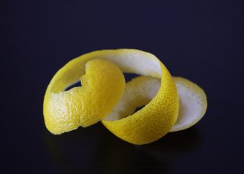Lemon peel spiral against dark background.